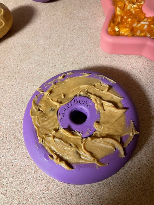 A purple Freez Doughnut filled with peanut butter and kibble